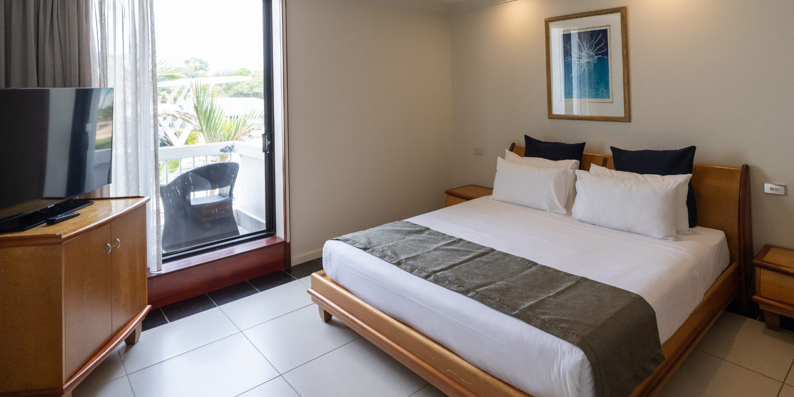 Hotel room featuring a bed, TV, and patio.