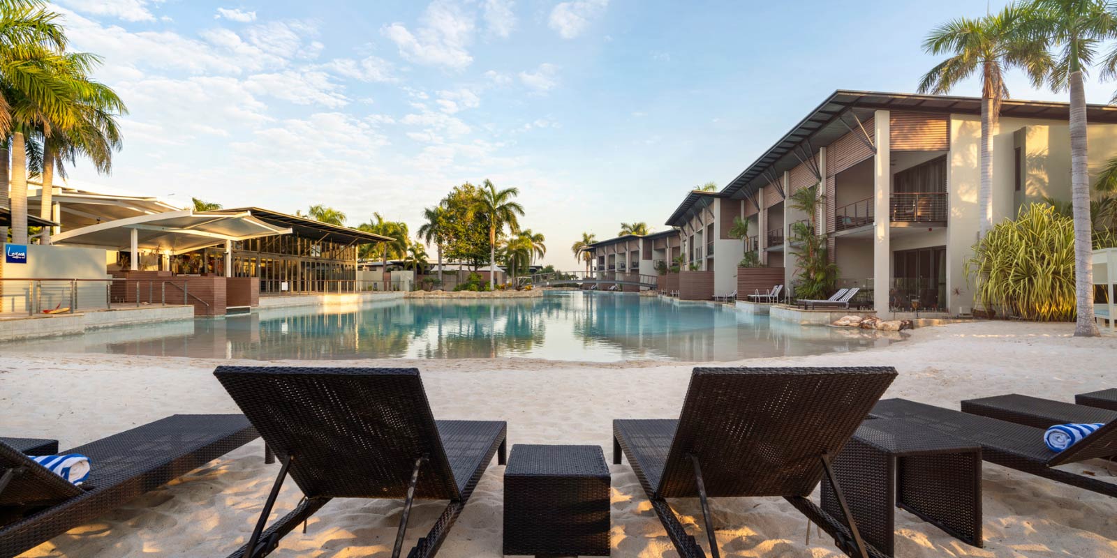Patio chairs facing an enclosed beach at the hotel.